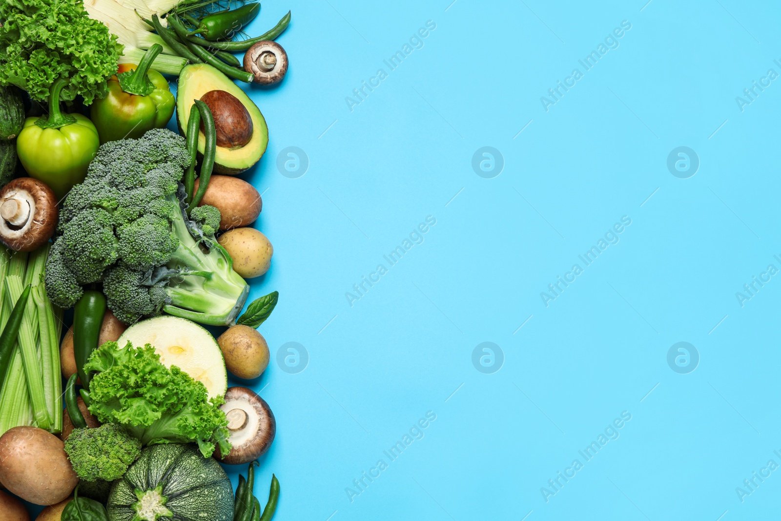 Photo of Flat lay composition with fresh vegetables on light blue background. Space for text