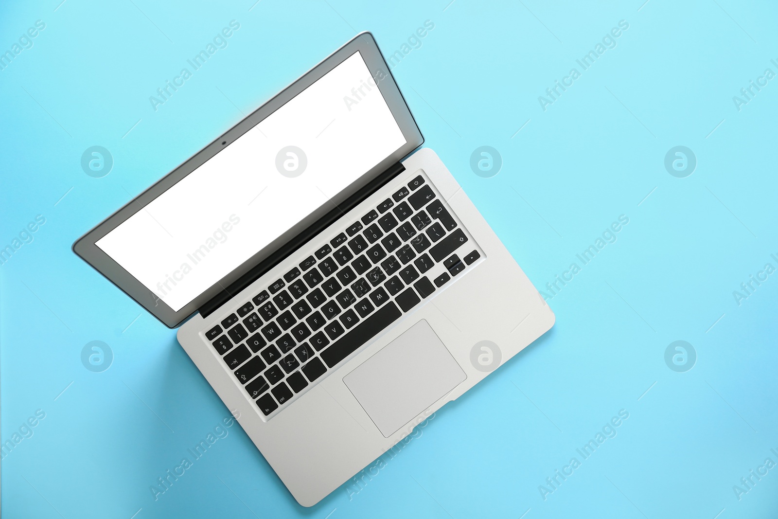 Photo of Modern laptop with blank screen on light blue background, top view