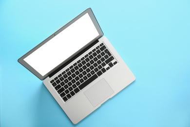 Photo of Modern laptop with blank screen on light blue background, top view