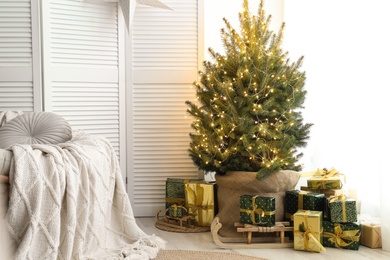 Photo of Many different gifts under Christmas tree indoors