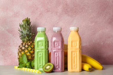 Photo of Bottles with healthy detox smoothies and ingredients on table