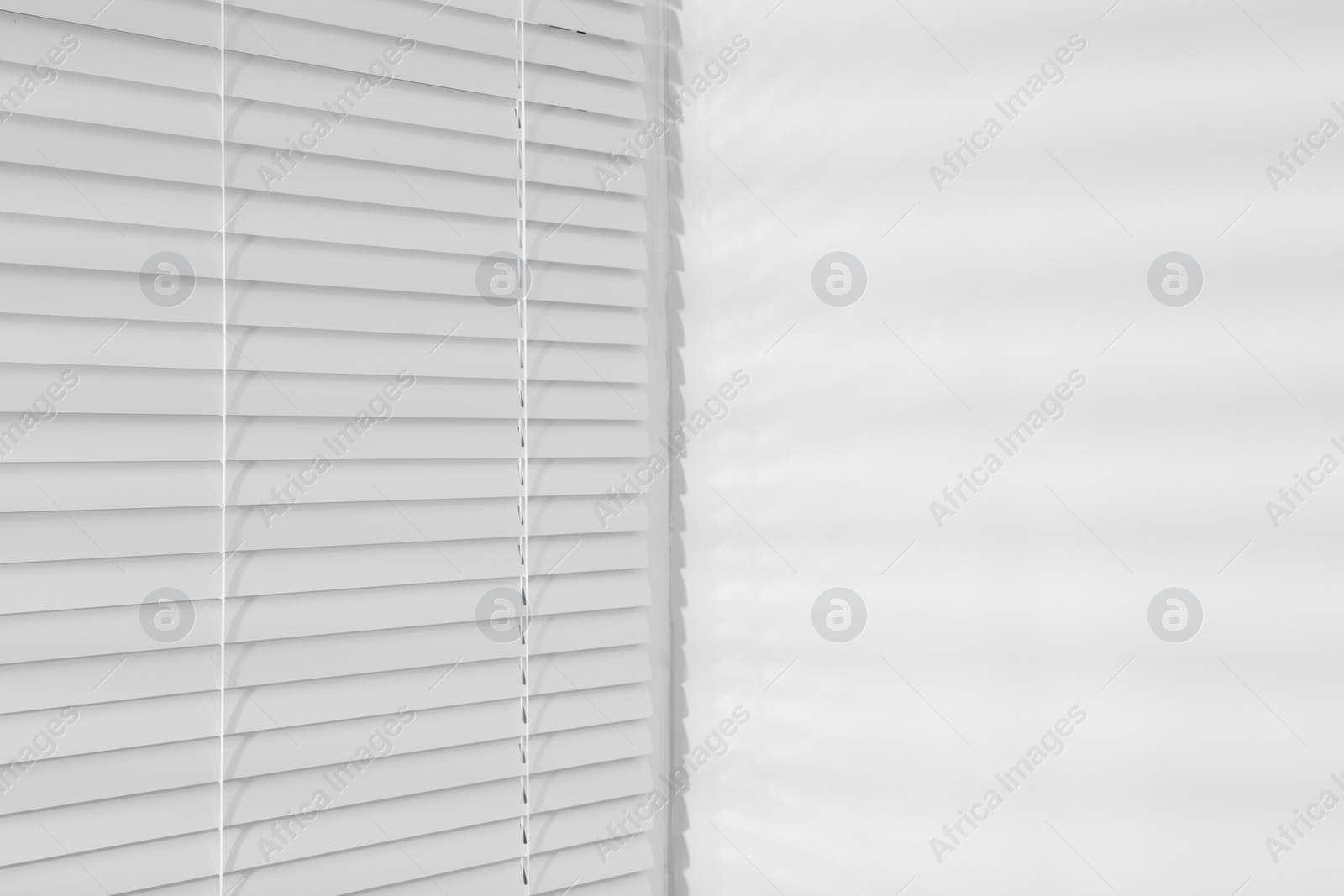 Photo of Stylish window with horizontal blinds in room