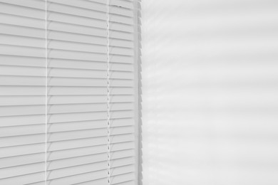 Stylish window with horizontal blinds in room