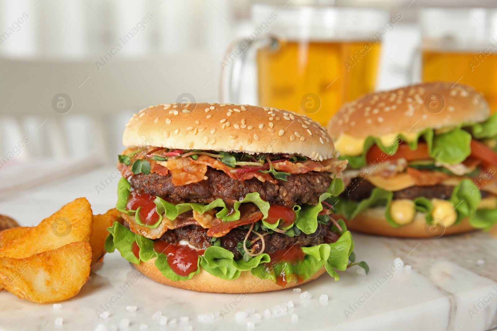 Photo of Tasty burgers with bacon and fried potatoes served on board