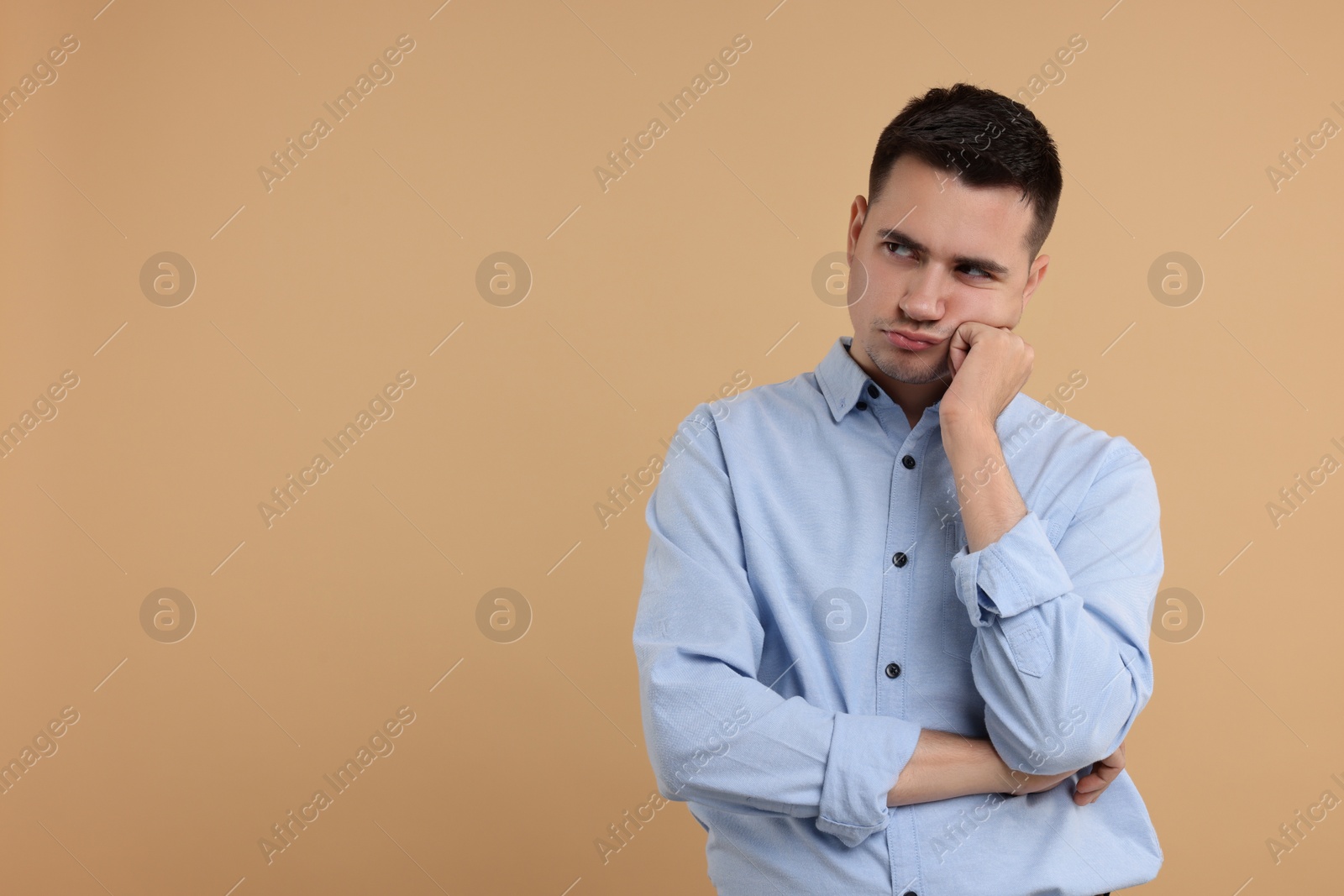 Photo of Portrait of resentful man on beige background, space for text