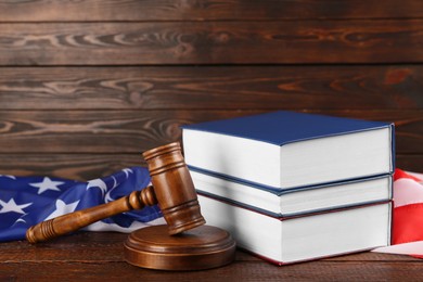 Photo of Judge's gavel, books and American flag on wooden table