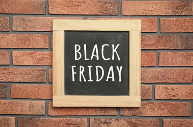 Image of Small chalkboard with text BLACK FRIDAY hanging on brick wall