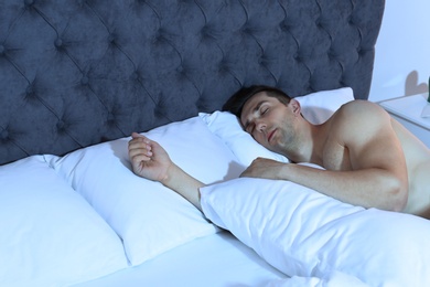 Photo of Young man sleeping in bed at night