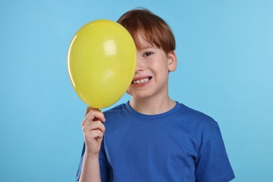 Photo of Boy with yellow balloon on light blue background