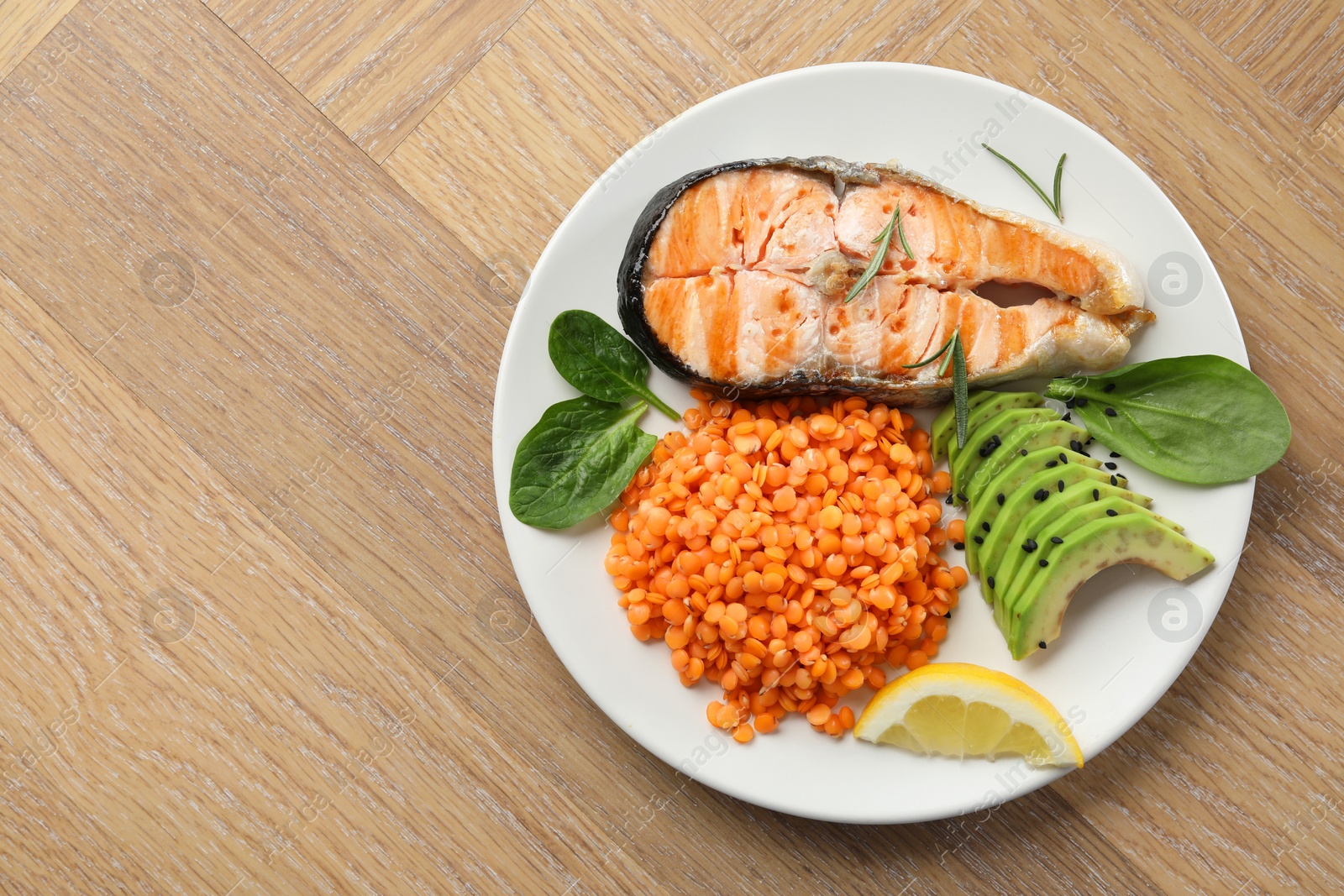 Photo of Plate with healthy food high in vegetable fats on wooden table, top view. Space for text