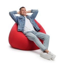 Photo of Happy man resting on red bean bag chair against white background
