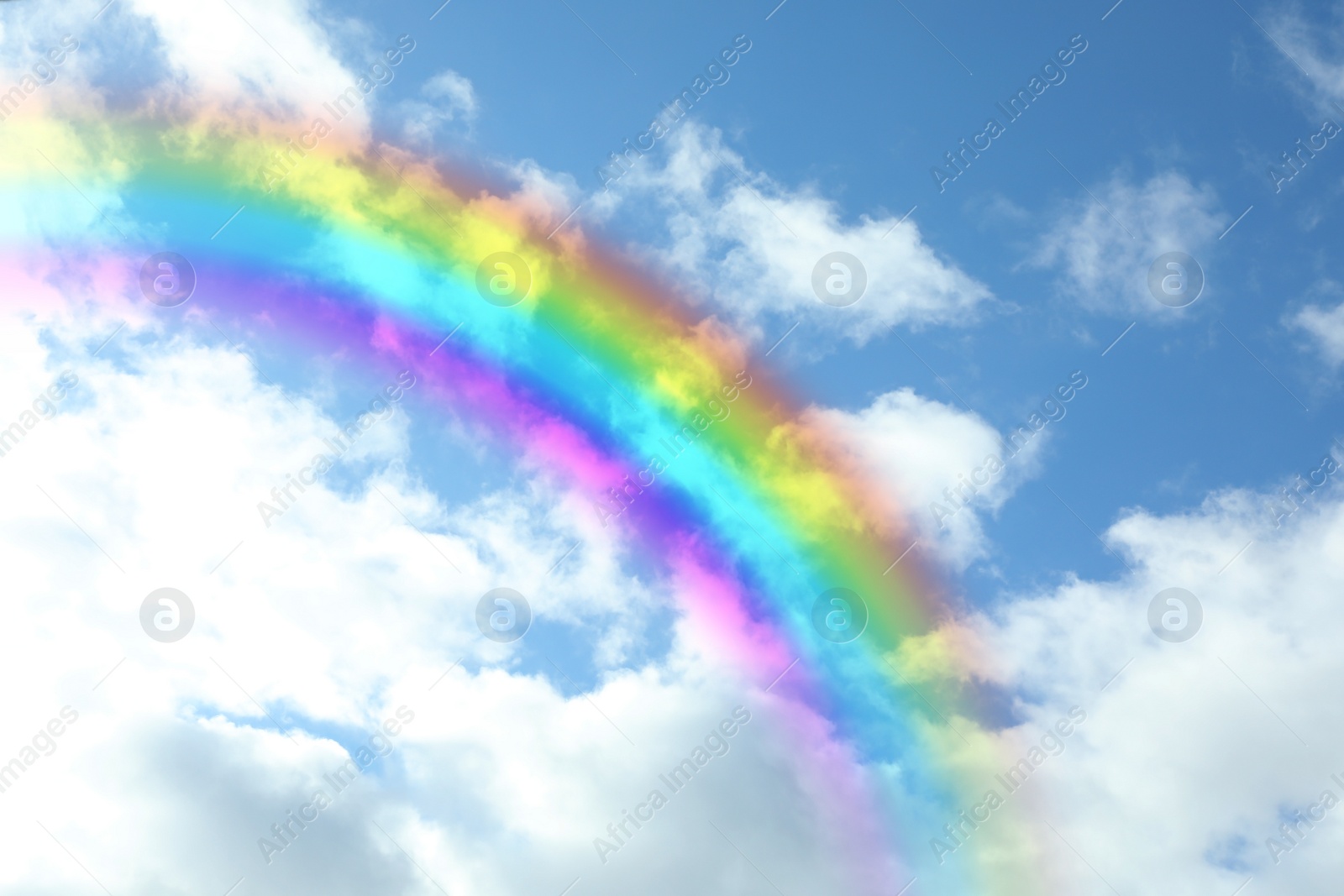 Image of Beautiful view of bright rainbow in blue sky on sunny day