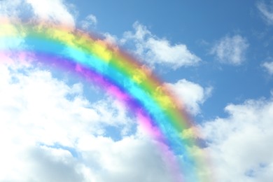 Beautiful view of bright rainbow in blue sky on sunny day