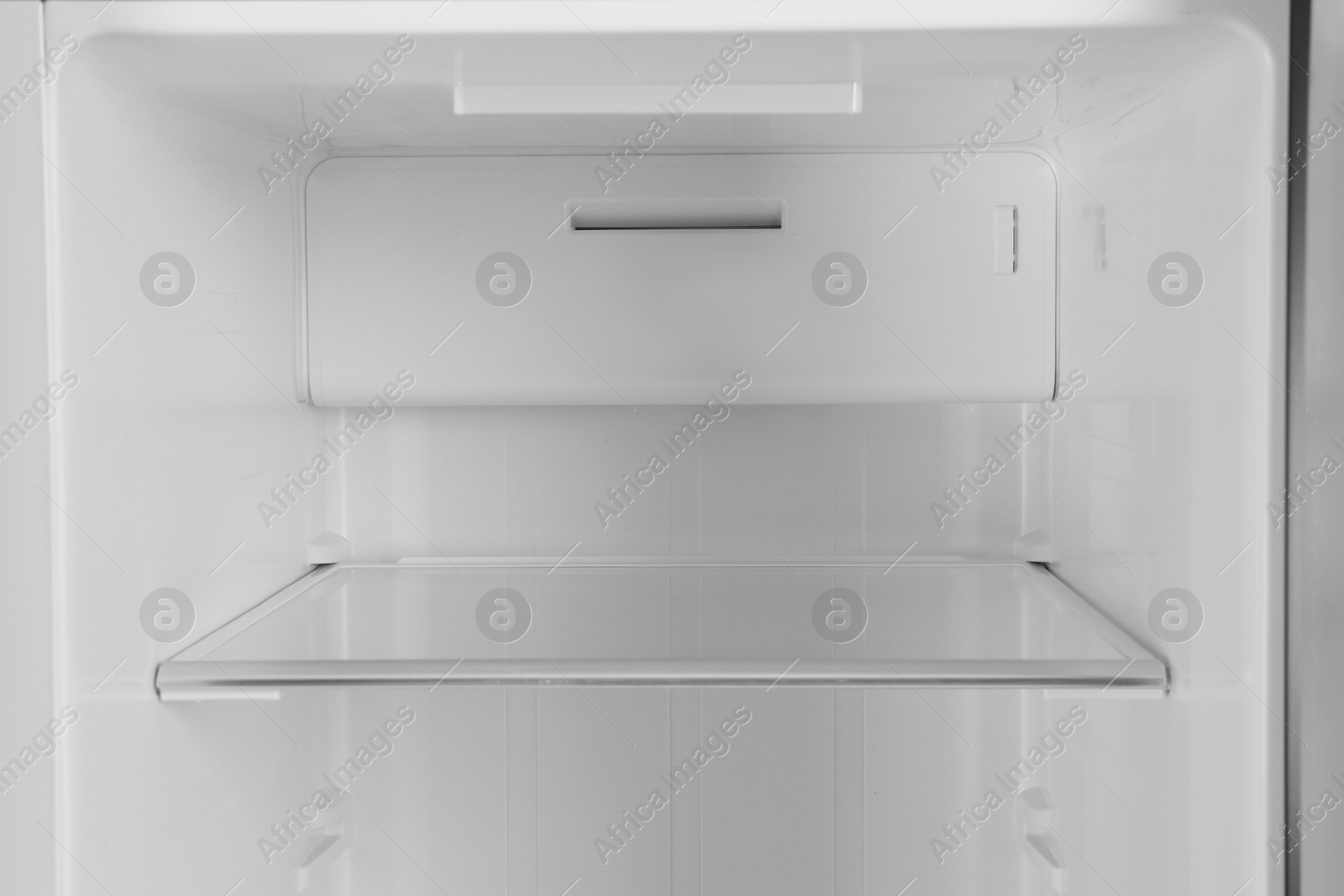 Photo of Shelf of empty modern refrigerator, closeup view