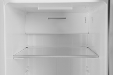 Shelf of empty modern refrigerator, closeup view