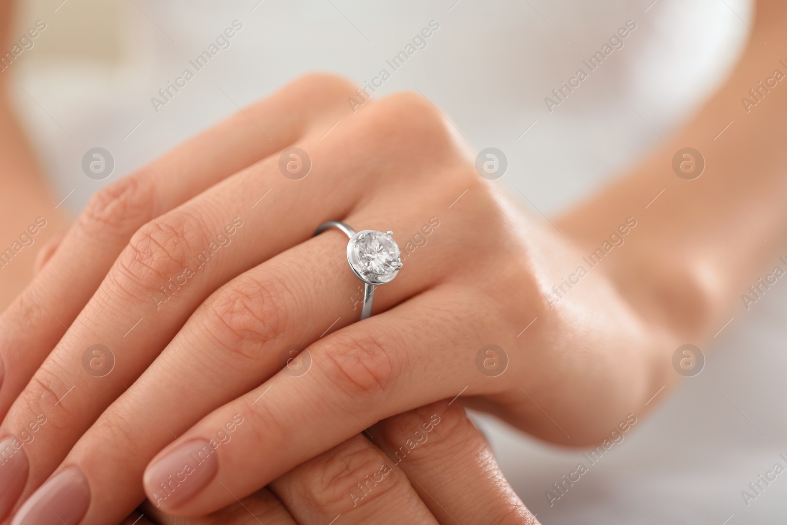 Photo of Young bride wearing beautiful engagement ring, closeup