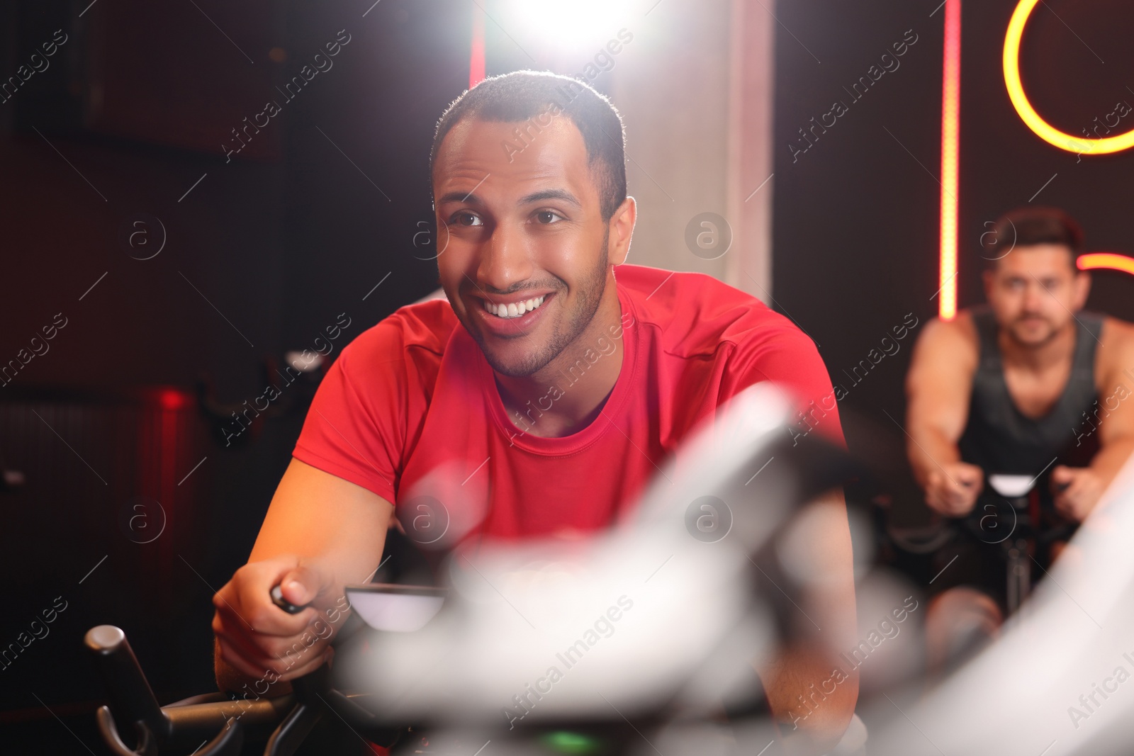 Photo of Men training on exercise bikes in fitness club