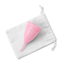 Photo of Pink menstrual cup with cotton bag on white background, top view