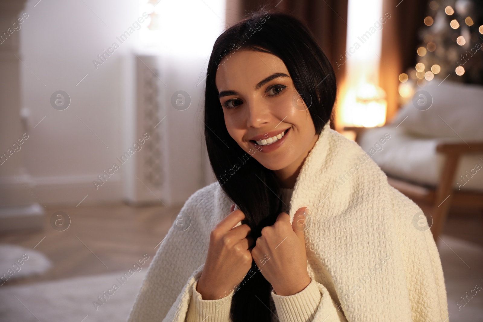 Photo of Beautiful woman covered in white plaid at home