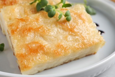 Photo of Delicious turnip cake with microgreens on table, closeup