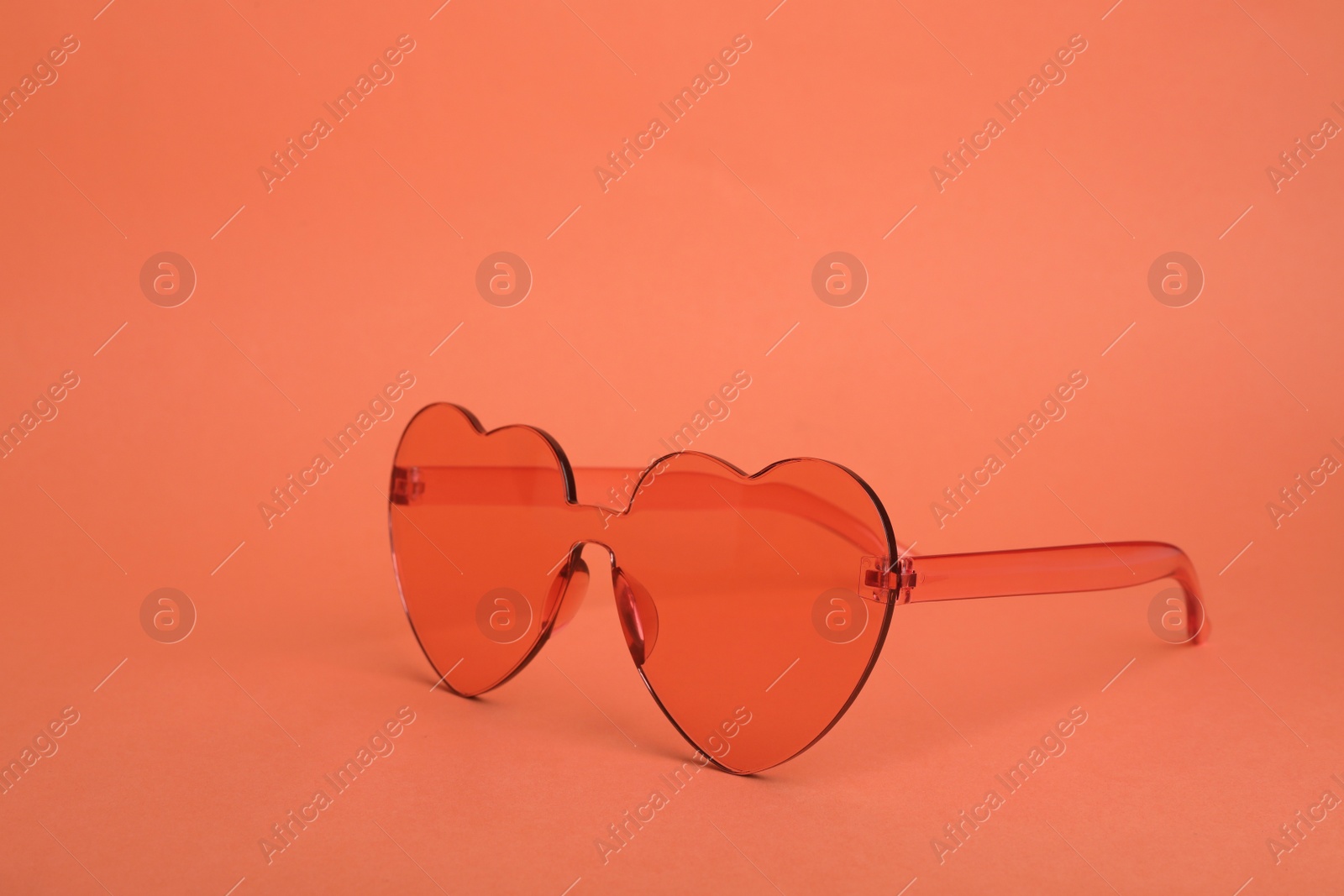 Photo of Heart shaped coral sunglasses on orange background