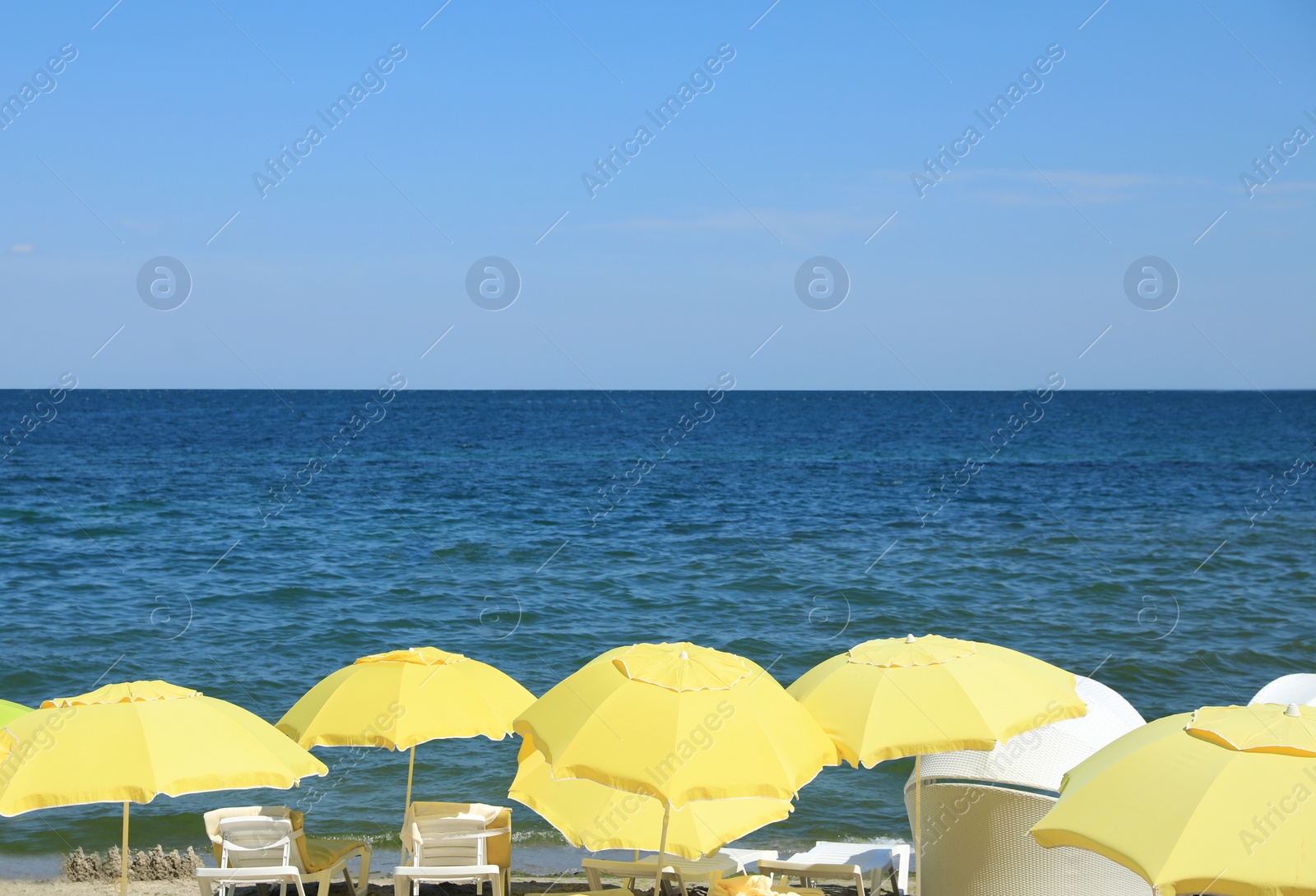 Photo of Many beach umbrellas at resort on sunny day