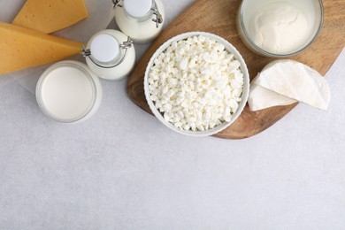 Different fresh dairy products on light table, flat lay. Space for text