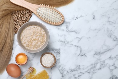 Flat lay composition with homemade hair mask in bowl on white marble table, space for text