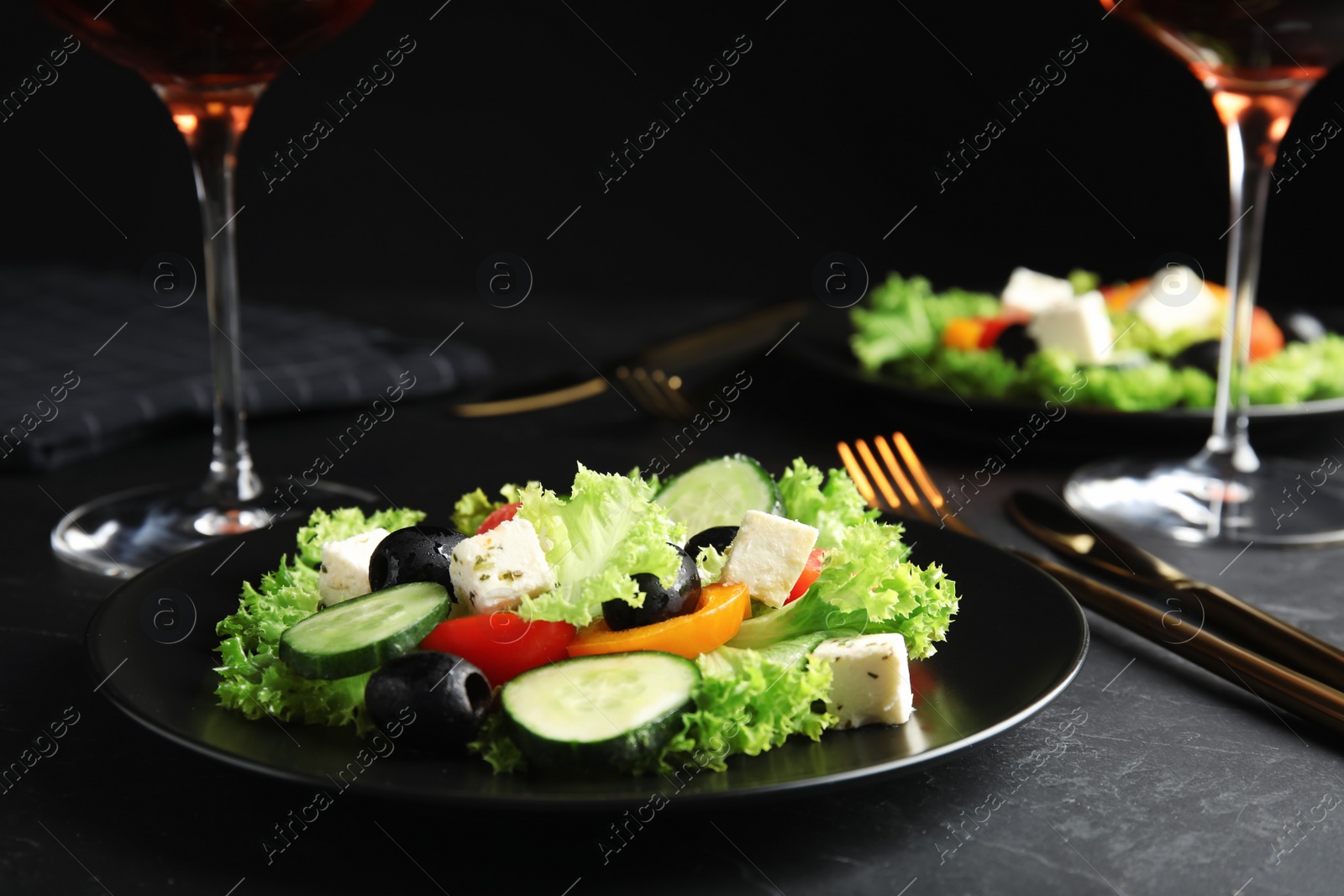 Photo of Tasty fresh Greek salad served on dark table