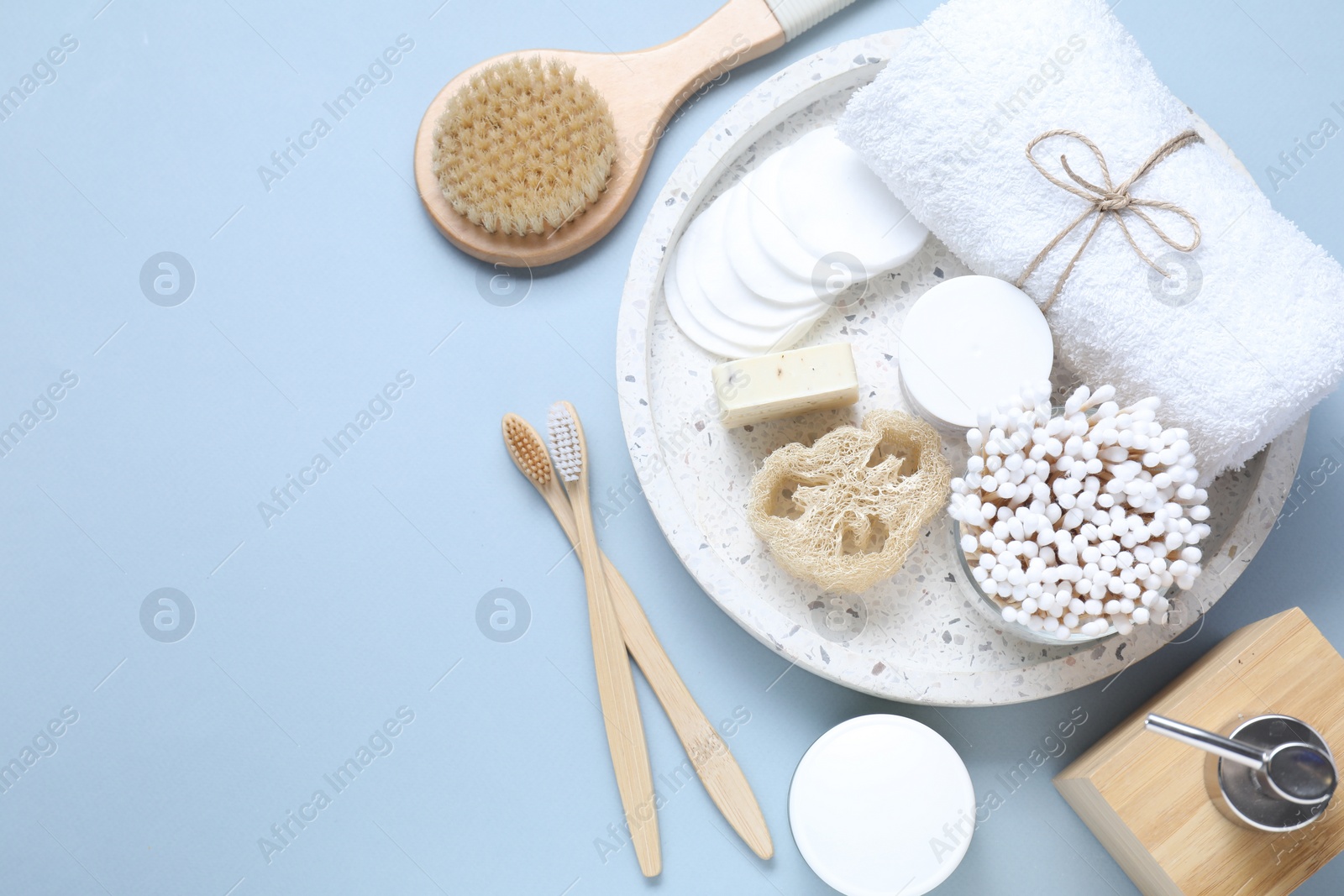 Photo of Bath accessories. Flat lay composition with personal care products on light blue background, space for text