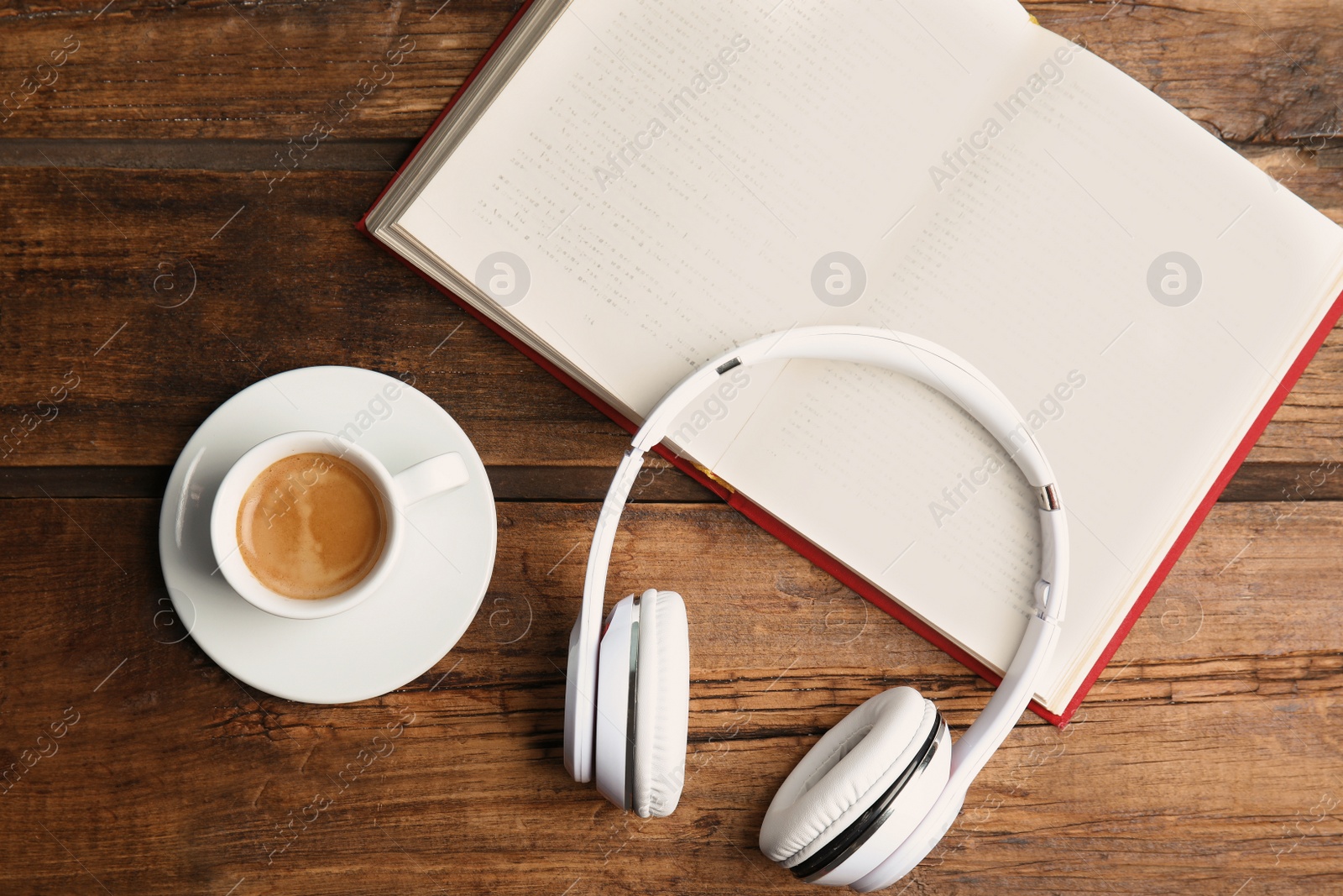 Photo of Book, coffee and headphones on wooden table, flat lay