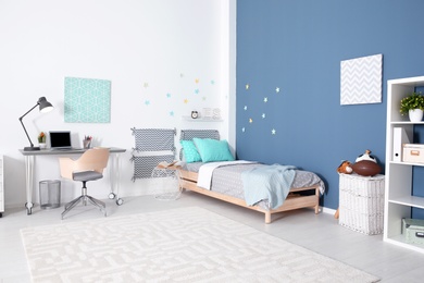 Photo of Modern child room interior with comfortable bed and desk
