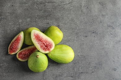 Photo of Fresh ripe figs on gray background, top view.  Space for text