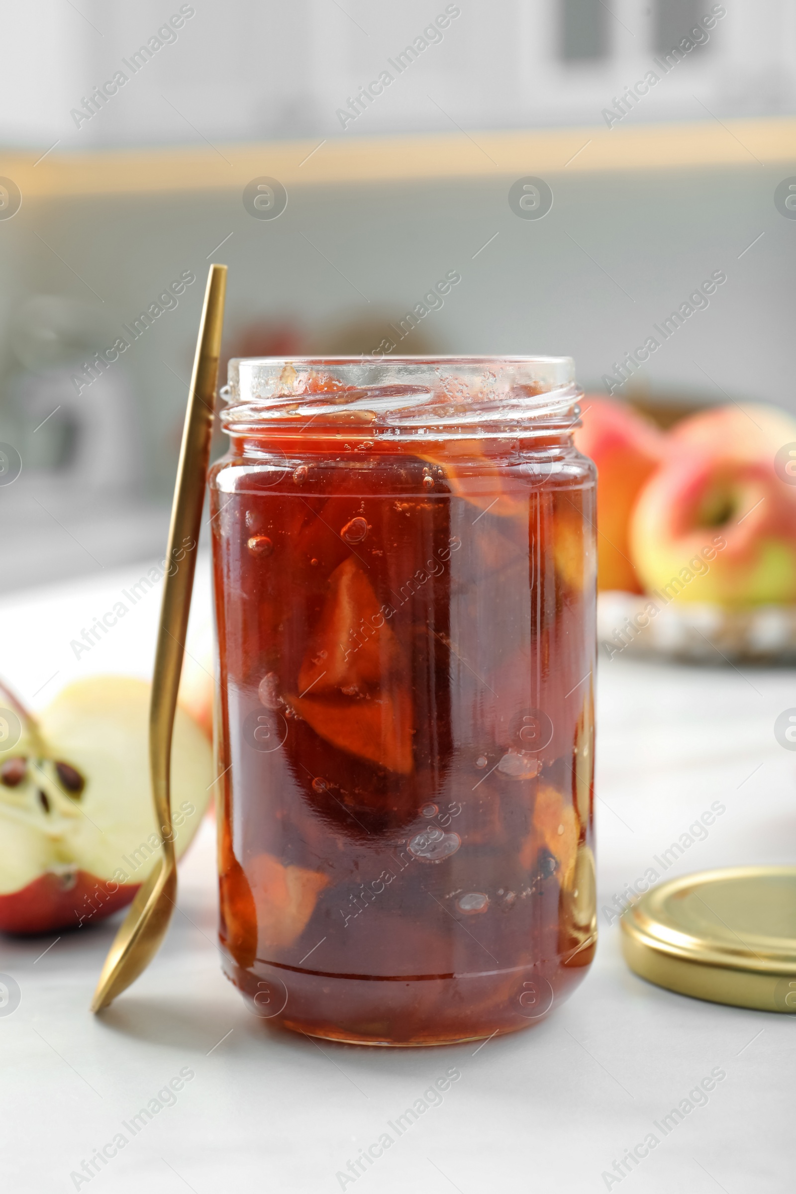 Photo of Delicious apple jam in jar and fresh fruit on white table