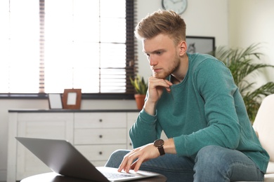 Young man using laptop in living room