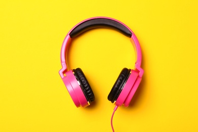 Stylish modern headphones on color background, top view