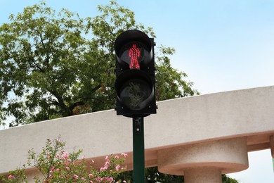 Photo of Traffic light with red signal near tree on city street
