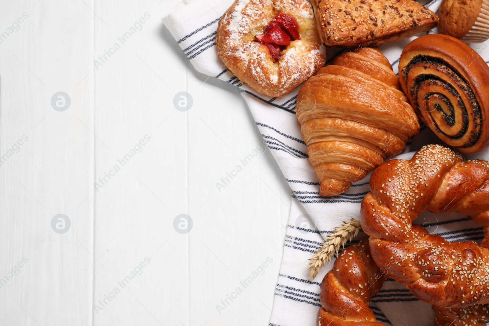 Photo of Different tasty freshly baked pastries on white wooden table, flat lay. Space for text