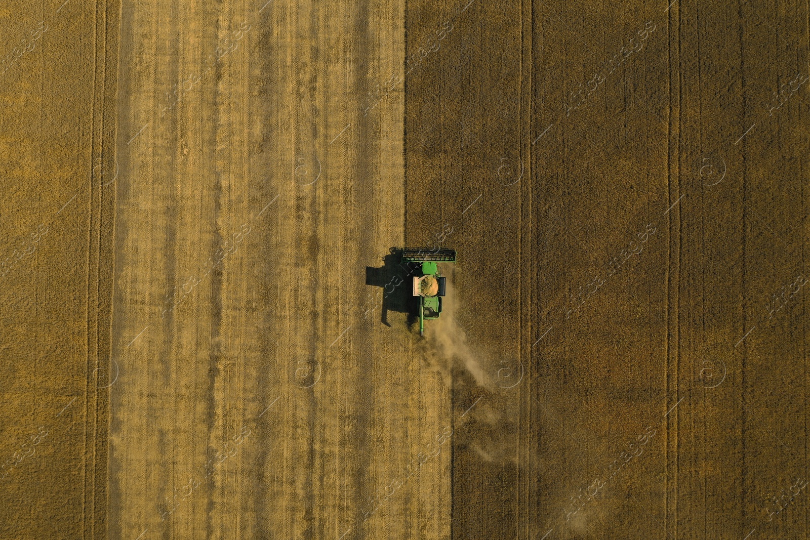 Photo of Beautiful aerial view of modern combine harvester working in field on sunny day. Agriculture industry