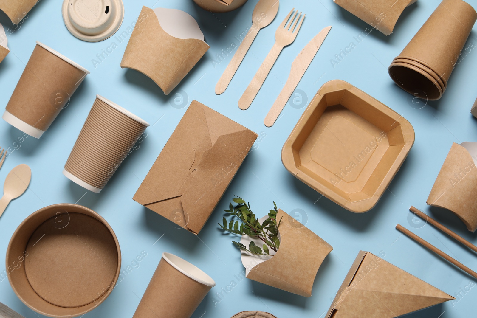 Photo of Flat lay composition with eco friendly food packagings and twigs on light blue background