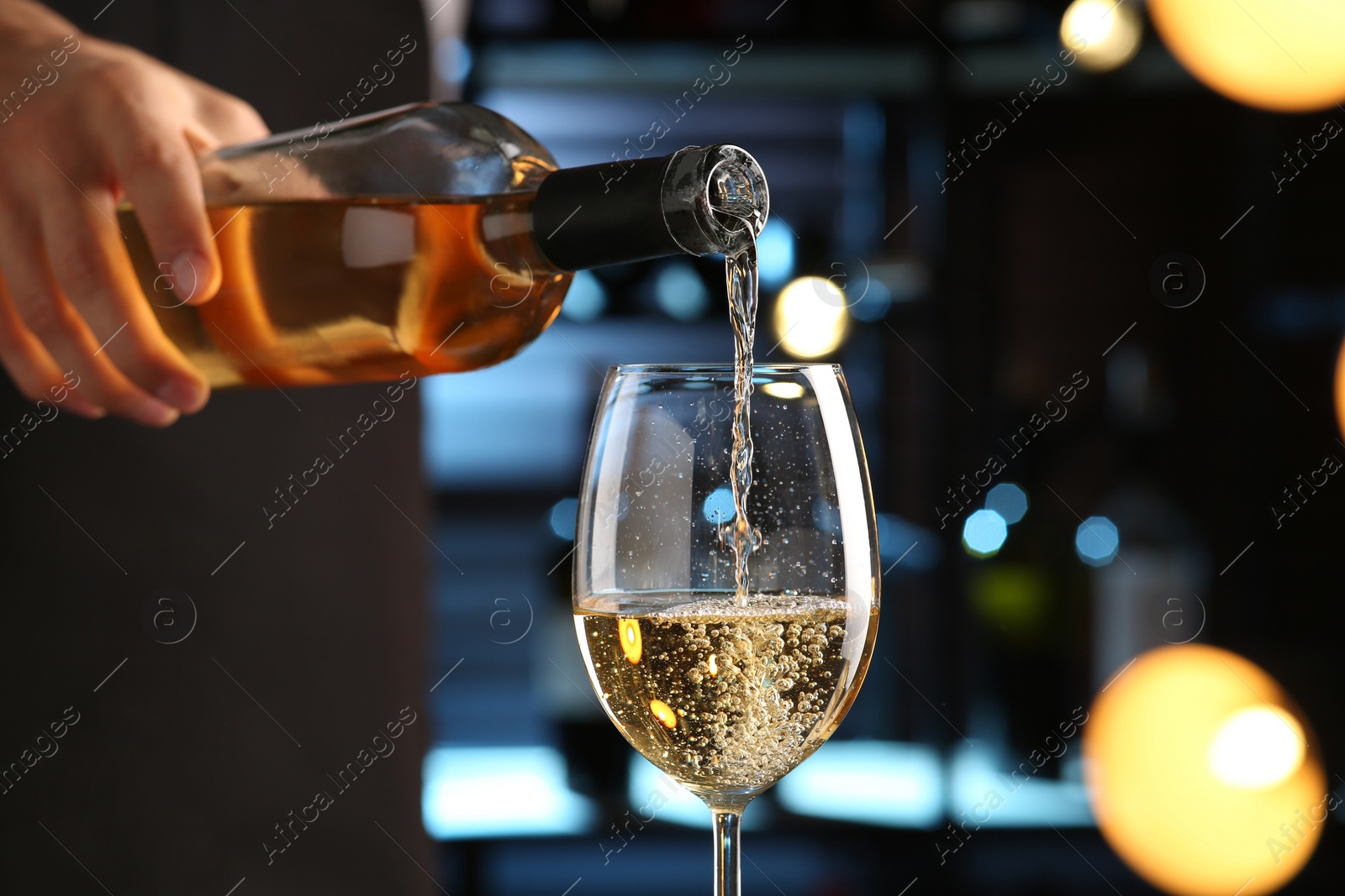 Photo of Bartender pouring white wine into glass indoors, closeup
