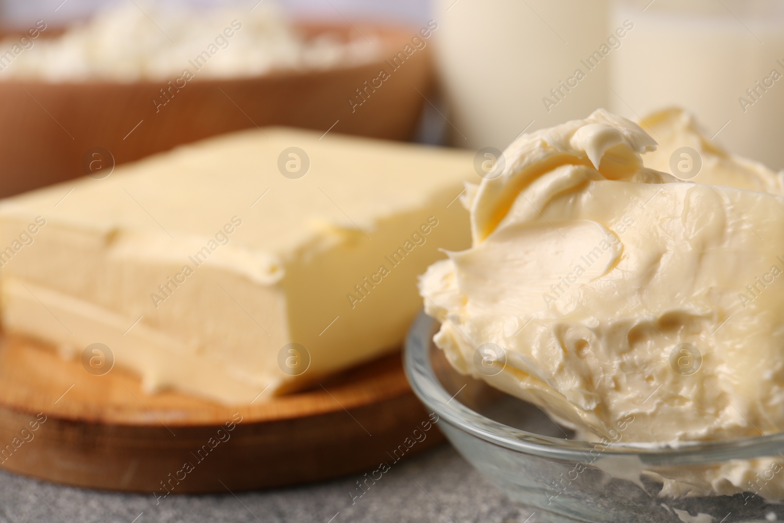 Photo of Tasty homemade butter and dairy products on grey table, closeup