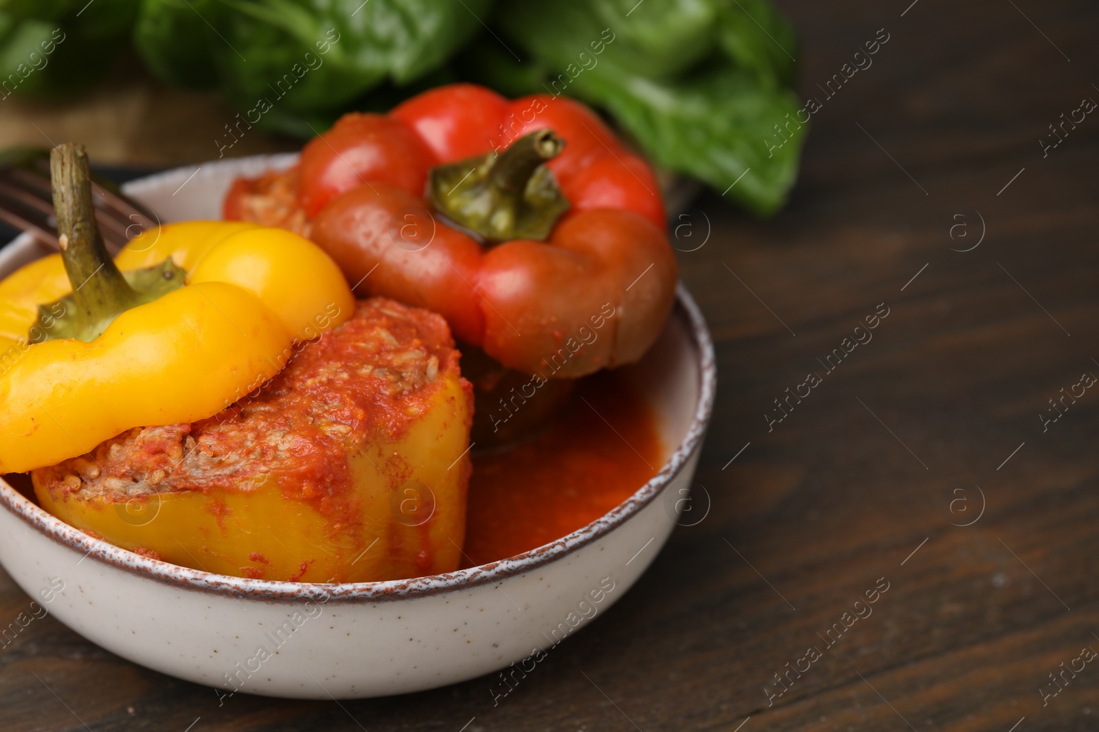 Photo of Delicious stuffed bell peppers served on wooden table, closeup. Space for text