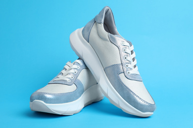 Photo of Pair of stylish sneakers on light blue background