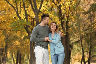 Photo of Happy lovely couple on walk in autumn park