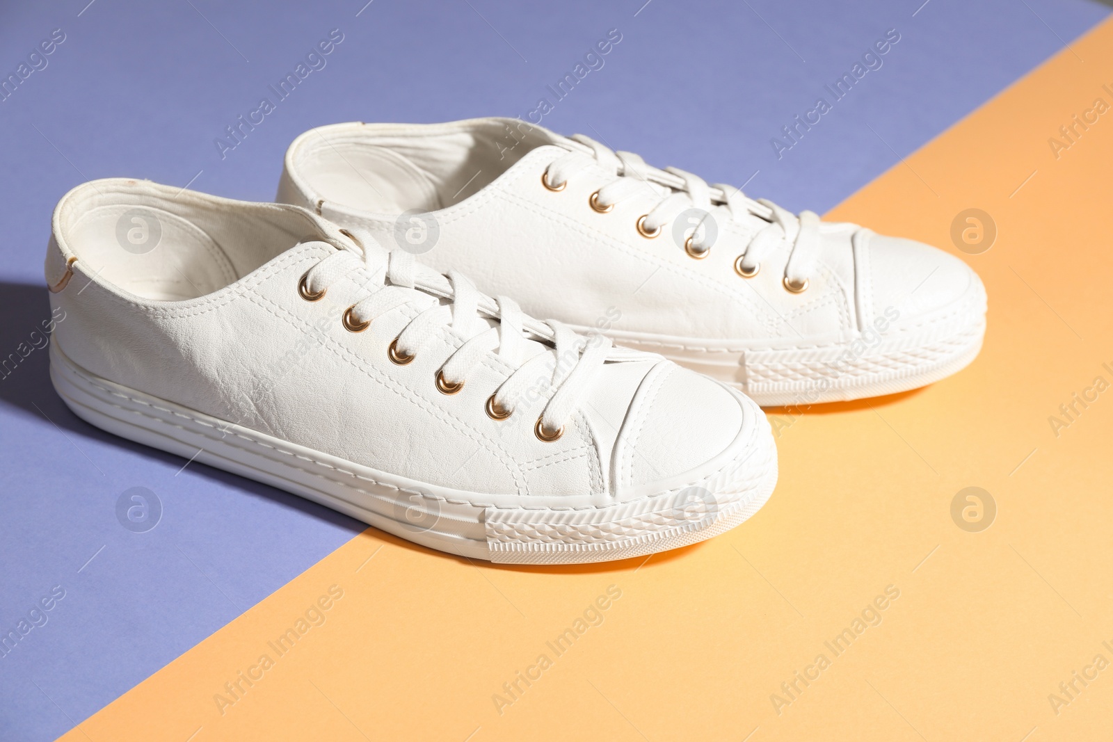 Photo of Pair of stylish sneakers on color background