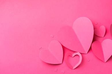 Photo of Paper hearts on pink background, flat lay. Space for text