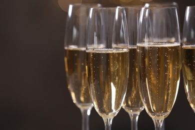 Glasses of champagne on dark background, closeup. Space for text