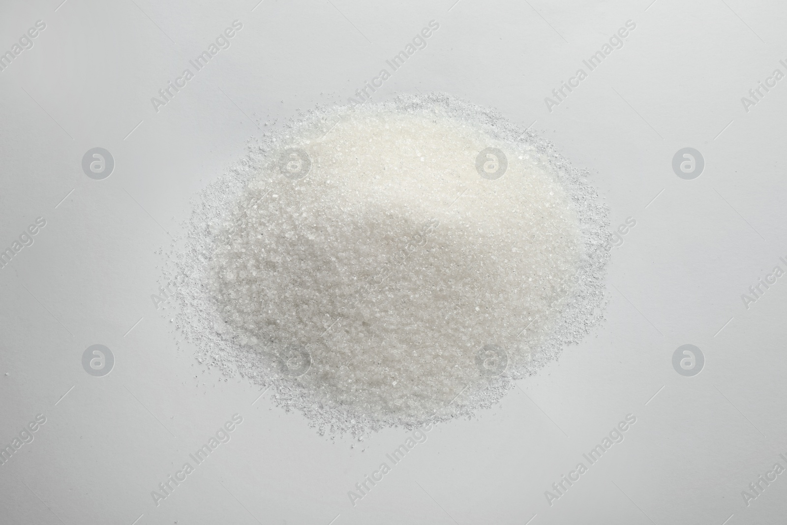 Photo of Pile of granulated sugar isolated on white