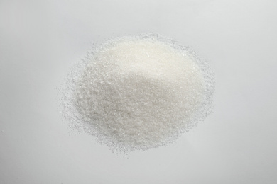 Photo of Pile of granulated sugar isolated on white